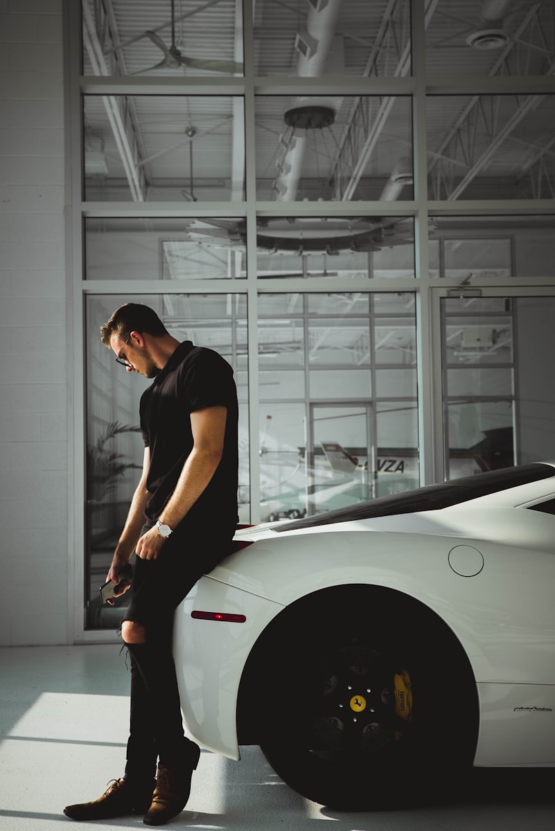 man sitting on car near glass window while buying a car
